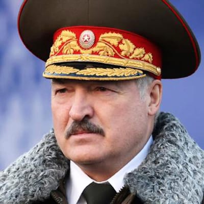 Lukashenka seisoo koppalakki päässään, paksulla turkiskauluksella varustetussa päällystakissa, jossa on kullaväriset olkalaatat.