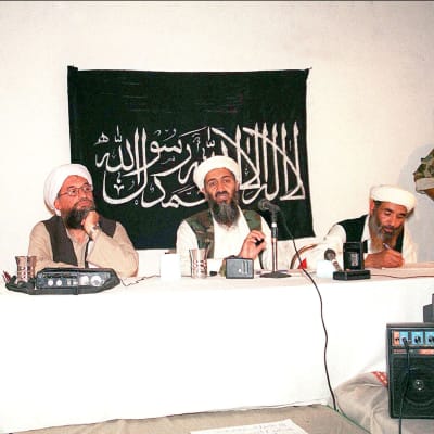 Ayman al-Zawahiri (till vänster vid bordet) brevid Usama bin Ladin på ett foto från maj 1998. 