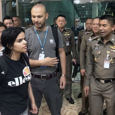 Rahaf Mohammed al-Qunun poistumassa Bangkokin lentokentältä thaiviranomaisten sekä UNHCR:n edustajien kanssa 7. tammikuuta 2019.