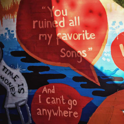 Värikäs seinämaalaus alikulkutunnelissa, jossa tekstit you ruined my favourite songs ja and now i can't go anywhere