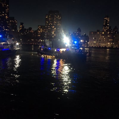 Räddningarbetare från brandkåren i New York intill helikoptervraket i East River, New York. 