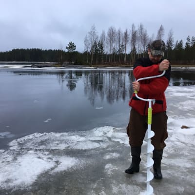 Etelä-Pohjanmaan kalatalouskeskuksen toiminnanjohtaja Marko Paloniemi kairaamassa jäähän reikää