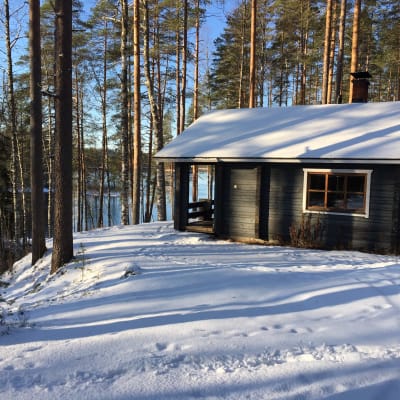 Mökki talvisessa jokimaisemassa Ruunaan luonnonsuojelualueella Lieksassa.
