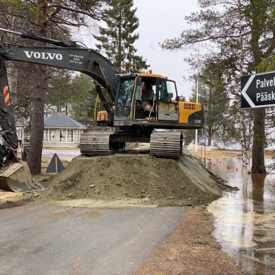 Kaivuri tekee hiekasta tulvaestettä Kittilän vanhainkodin edustalla.  