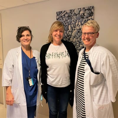 Tre kvinnor står i en sjukhuskorridor.