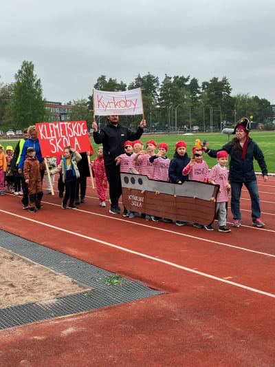 Kyrkoby skolas förskolebarn tågar in på idrottplanen iklädda piratkläder.