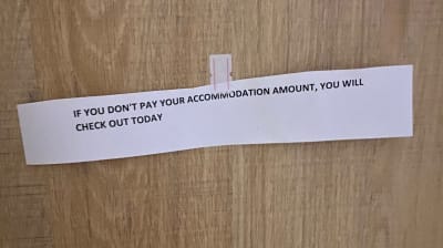 En lapp där ett hotell hotar en resenär med vräkning om de inte betalar för sin vistelse en andra gång.