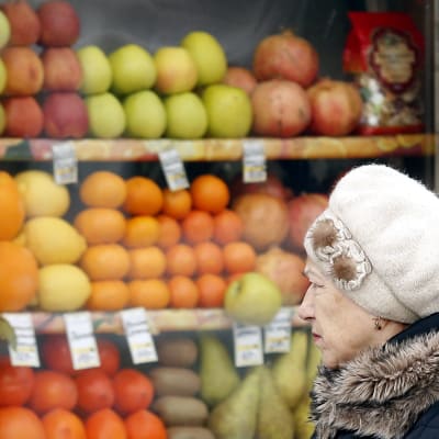 En kvinna går förbi en fruktbutik i Moskva.