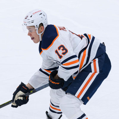 Jesse Puljujärvi för fram pucken på isen, iklädd Edmonton Oilers vita speldräkt.