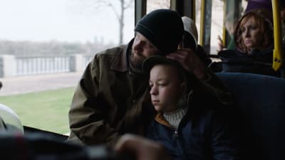 Yura (Yaroslav Bezkorovainyi) och Sasha (Mykhailo Korzhanivskyi) sitter i en buss och ser ledsna och trötta ut.