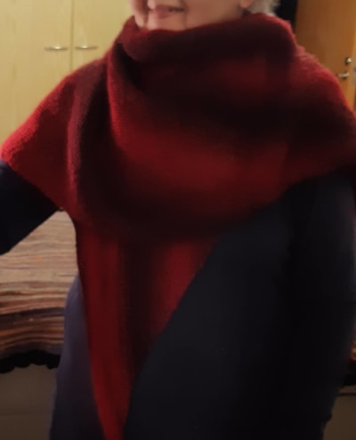 Kvinna med röd stickad sjal runt axlarna.