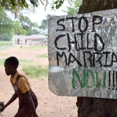 En skylt på en skolgård i Ghana uppmanar att upphöra med barnäktenskap.