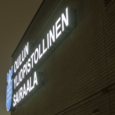 Oulun yliopistollisen sairaalan valologo seinässä.