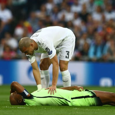 Vincent Kompany ligger och håller sig för pannan medan Pepe tröstar honom.