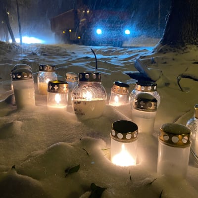 Kynttilöitä lumella liikenneonnettomuuden onnettomuuspaikalla Kuopion Hulkontiellä.
