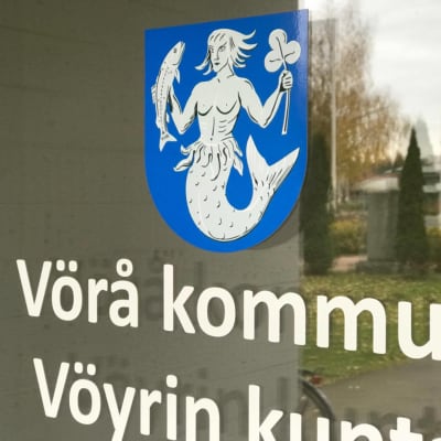 En närbild av dörren till Vörå kommungård som föreställer kommunvapnet.