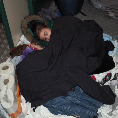 Irakiskt barn sover på wc-papper i cykelförvaret på nattåget från Kemi söderut.