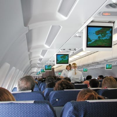 Inne i ett flygplan, vy från passagarerarsäte mitt i planet.