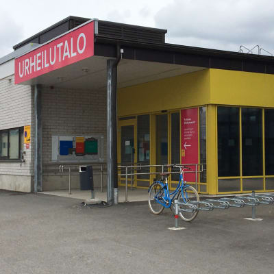 Punainen urheilutalon kyltti sisäänkäynnin yläpuolella.
