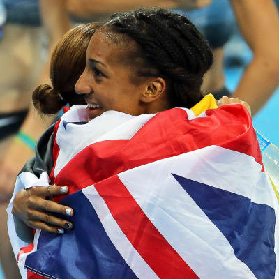 Sjukampare kramar om varandra omsvepta av en brittisk flagga.