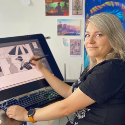 Sarjakuvataiteilija Sunna Kitti piirtää työnsä ääriviivoja tietokoneen näytölle. 