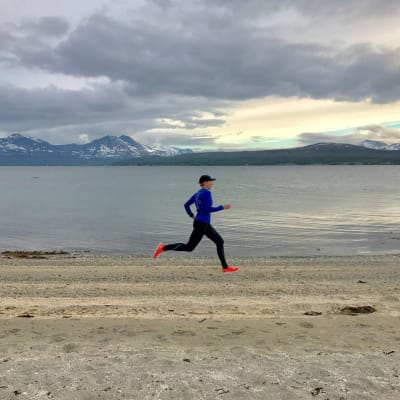 Nainen juoksee Jäämeren rannalla Norjassa.