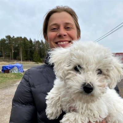 Mari Lindström med sin hund i famnen