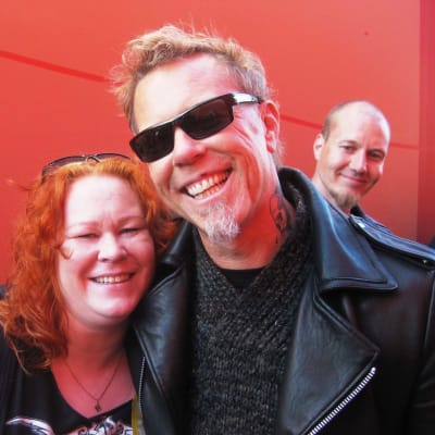 Metallica-fani Hanna Erolahti poseeraa kameralle Metallican laulaja-kitaristi James Hetfieldin kanssa Meet & Greet -tapahtumassa Helsingissä.