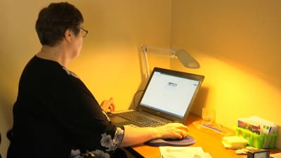 Ingrid Hollmérus-Nilsson sitter framför en dator. 
