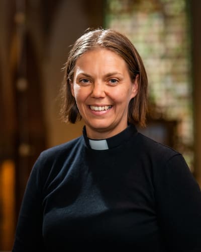 En kvinnlig präst i en kyrka.