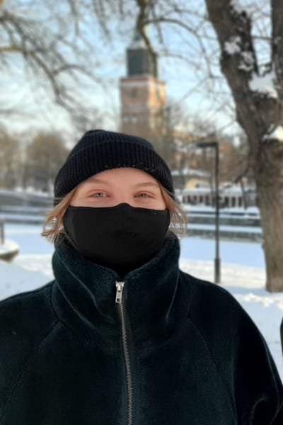 Amanda Holm och Aare Kiviranta, två ungdomar med svarta munskydd står vid ett snöigt torg med Åbo Domkyrka och Katedralskolan i bakgrunden.