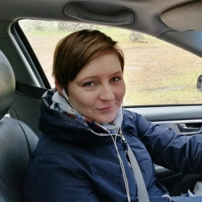 Katja Palosaari kör bil och lyssnar på radio.