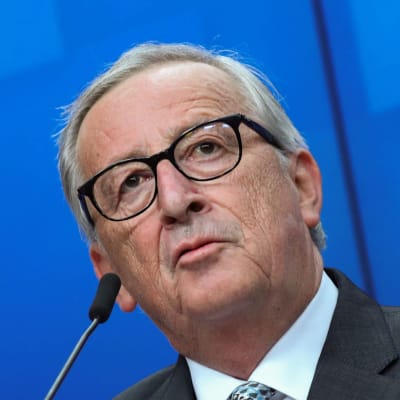 En kostymklädd Jean-Claude Juncker står bakom ett podium och talar i en mikrofon.