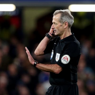 Fotbollsdomare signalerar för VAR-beslut.