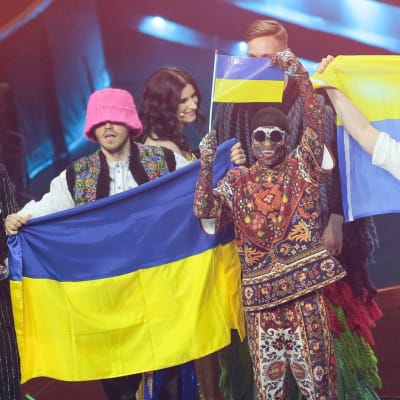 Kalush Orchestra poserar med Ukrainas flagga på Eurovisionsscenen.