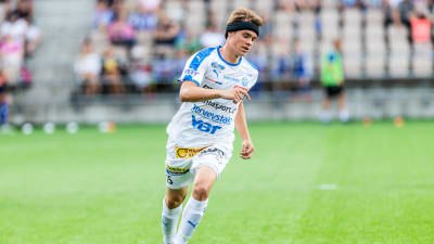 Vitklädd RoPS-spelare dribblar med boll.