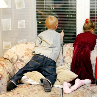 Lapset odottavat joulupukkia ikkunassa.