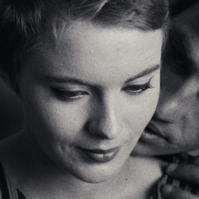 Mustavalkoisessa lähikuvassa lyhyttukkainen nuori nainen (näyttelijä Jean Seberg) katsoo alaviistoon vienosti hymyillen, hänen takanaan olkaan nojaa mies (näyttelijä Jean-Paul Belmondo) huulet hieman raollaan, sormet naisen olkapäällä, kuva elokuvasta Viimeiseen hengenvetoon.