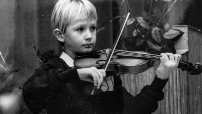 En svartvit bild Jakob som barn när han spelar violin.