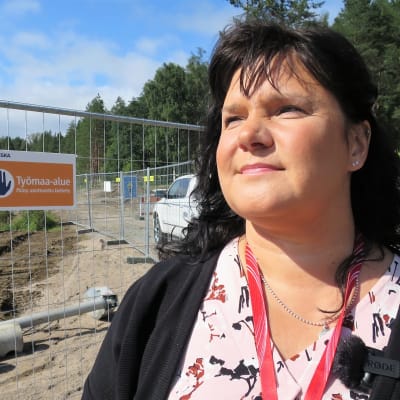 Tehyn pääluottamusmies Piritta Järvinen seisoo Assi-sairaalan työmaa-aidan takana