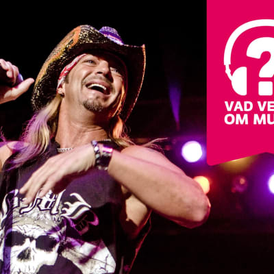 Bret Michaels ler stort med öppen mun och håller i en mikrofon som är i en mikrofonställning.