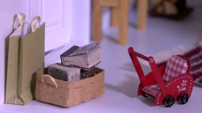 Böcker i korg och barnvagn i miniatyr