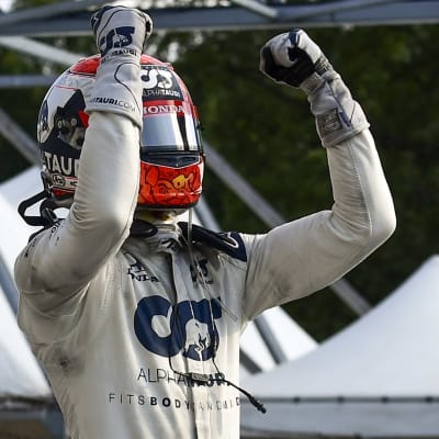 Pierre Gasly firar med händerna, iklädd hjälm och halare.