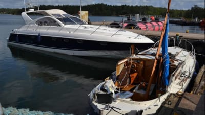 Två båtar förtöjda vid en brygga efter att de kolliderat med varandra. Den mindre båten, en motorseglare, har stora skador på babords sida.