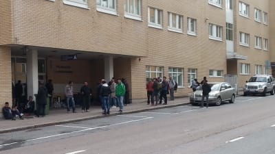 Ett gäng asylsökande utanför polisstationen i Åbo.