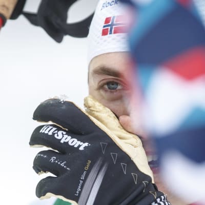 Jarl Magnus Riiber laittaa hanskan kasvojen eteen.