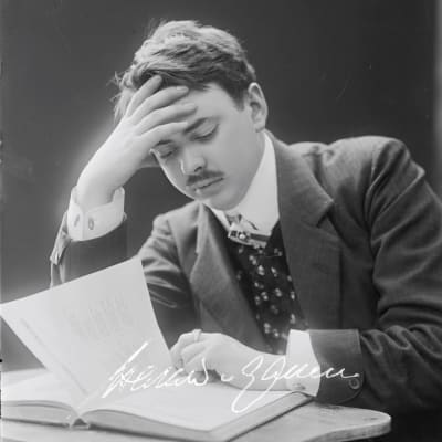 Harald Gallén lutad över en bok. Början av 1900-talet.