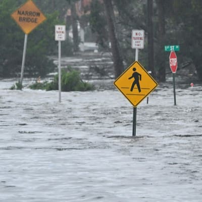Översvämmade gator med skyltar som sticker upp över ytan.