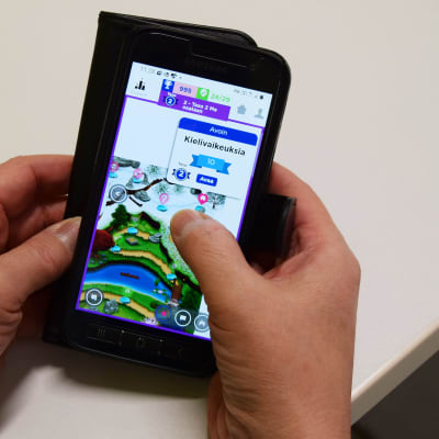 Värikäs Seppo-peli älypuhelimen näytöllä ihmisen käsissä. 