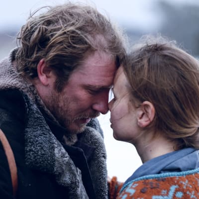 Janne (Linus Troedsson) och Maja (Amanda Jansson) visar ömhet för varandra genom att ha näsorna mot varandra. Paret är filmat ute och bilden är en stillbild från filminspelningar av filmen Stormskärs Maja.